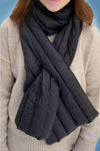 A down scarf with its own bag. It comes in black, grey, and olive.