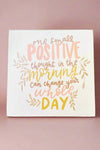 4 inch solid wood block sign painted white with “one small positive thought in the morning can change your whole day” written in pastel pink and yellow.