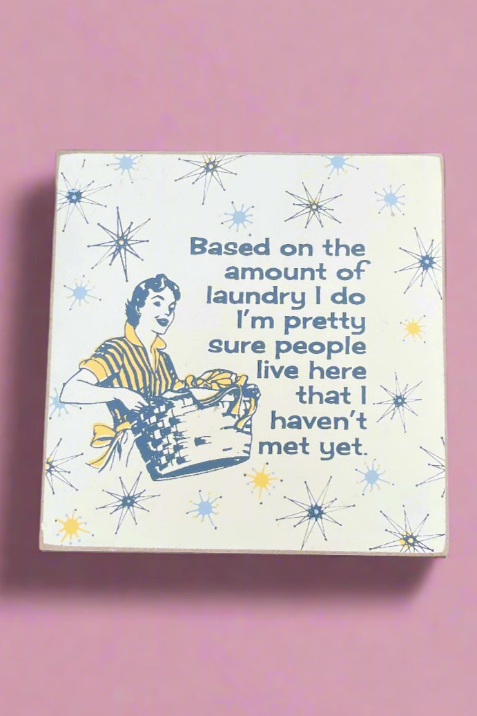 4 inch solid wood block sign with quirky retro print and quote that reads, “Based on the amount of laundry I do I’m pretty sure people live here that I haven’t met yet.”