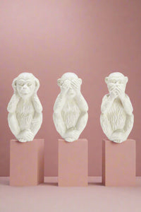 A set of 3, white monkey figurines. Each monkey displays hear no evil, see no easily, or speak no evil. 