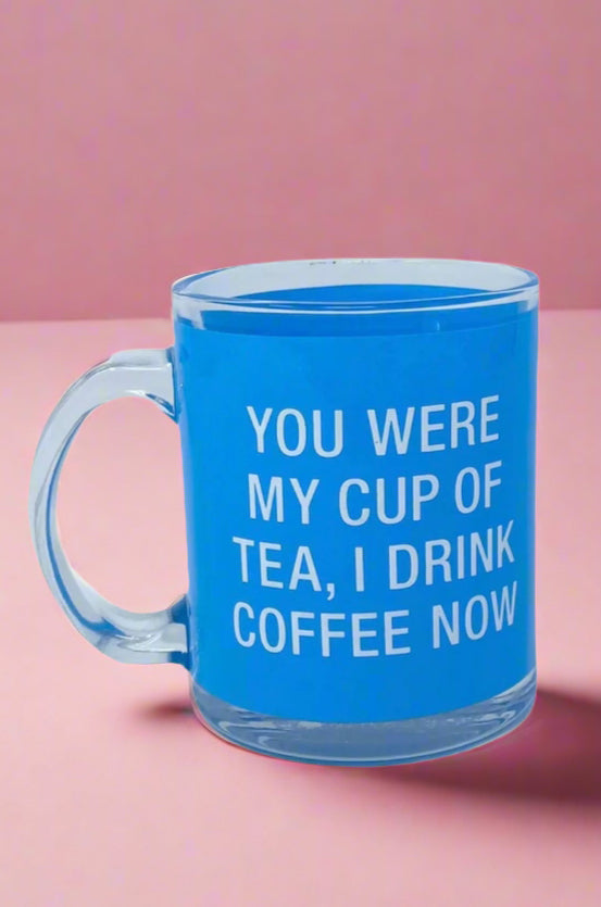 A glass mug in blue that says ‘You were my cup of tea, I drink coffee now.’ Hand wash only.