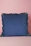 An indigo blue accent pillow with fringe and stitching details. 